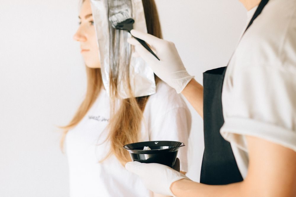 Stylist painting color between foils